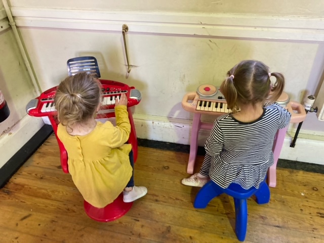 Two children play musical instruments at Playaway