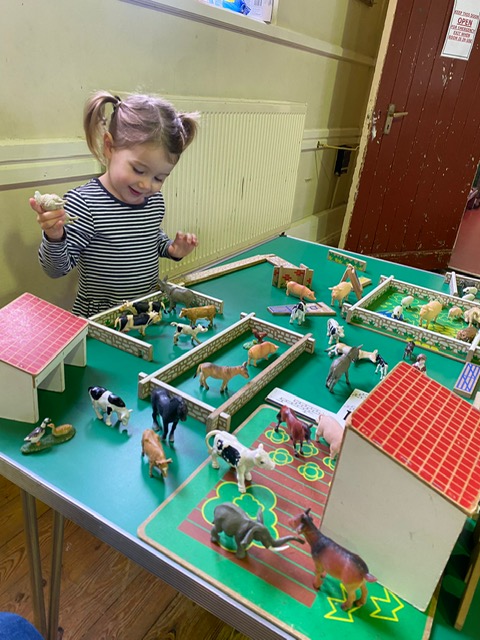 A child enjoys playing with toys at the Zoo table at Playaway