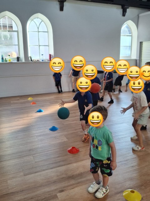 Boys playing ball games in the hall - with emojis covering their faces for privacy