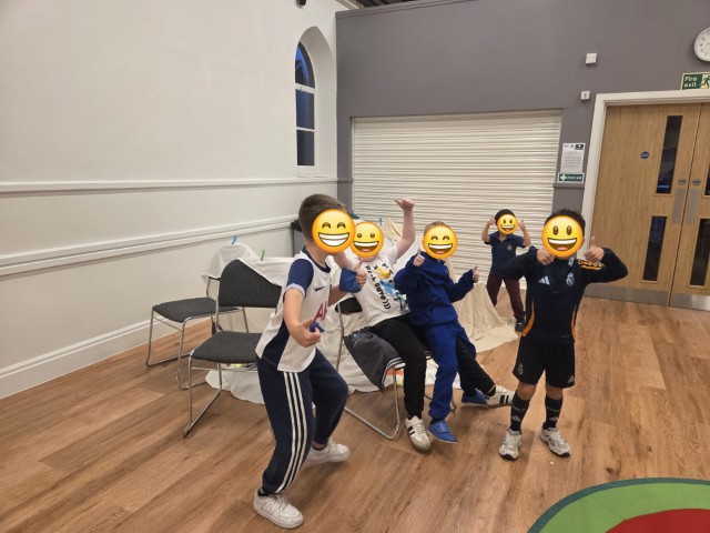 Boys giving a big thumbs next to in the tent they've made - with emojis covering their faces for privacy